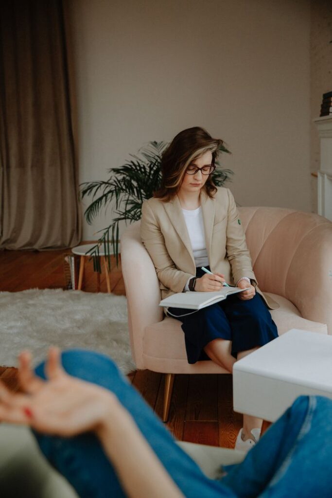 The Art of Drawing Readers In: Your attractive post title goes here Female therapist writing notes during a counseling session, focusing on mental health.